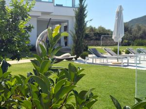 a garden with lounge chairs and an umbrella at Villa Veneti in Pérdika +46 photos