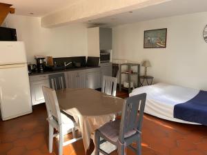 a kitchen and dining room with a table and a bed at Les Logis de la Vaucouleurs in Rosay +22 photos
