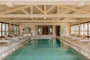 a swimming pool with chairs and a table in a building at Château de Valmer in La Croix-Valmer