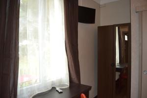 a window with a white curtain and a desk with a mirror at La Casa Mia in Sainte-Maxime