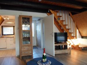 a living room with a staircase and a television at Haus Maya H-12 in Butjadingen