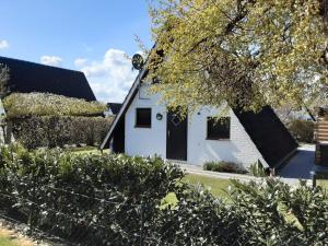a white house with a black roof at Haus Maya H-12 in Butjadingen