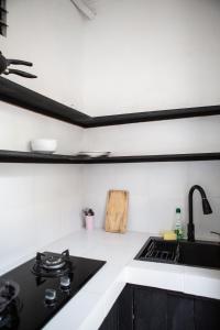 a kitchen with a black stove and a sink at Parafrutts Apartments by Ateliero in Ubud +89 photos