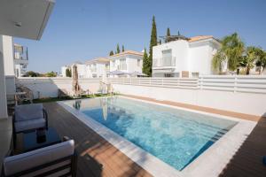 a swimming pool in front of a house at Paez Villa - Private Pool - 3BR - Walk to Beach - Pernera Protaras in Protaras