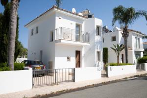 a white house with a car parked in front of it at Paez Villa - Private Pool - 3BR - Walk to Beach - Pernera Protaras in Protaras