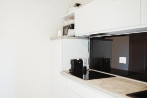 a kitchen with white cabinets and a counter top at Corte Altobelli Rooms Bitonto in Bitonto