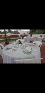 a long white table with plates and glasses on it at SDQ apartamentos in Cancino