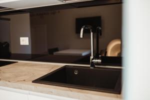 a kitchen sink with a faucet on a counter at Corte Altobelli Rooms Bitonto in Bitonto +66 photos
