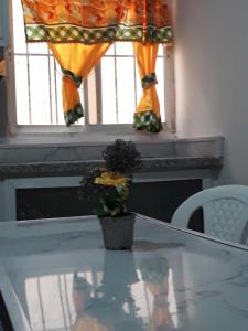 a table with a window and a vase with flowers on it at SDQ apartamentos in Cancino
