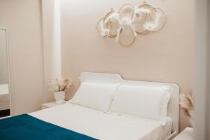 a bedroom with a white bed with a flower on the wall at Corte Altobelli Rooms Bitonto in Bitonto