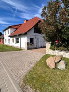 a white house with a red roof at Strandläufers Ruhe in Wiepkenhagen
