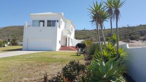 a white house with a horse in front of it at Seaview Villa in Yzerfontein