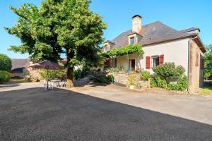 a house with a tree and an umbrella in front of it at Maison De Campagne in Ligneyrac