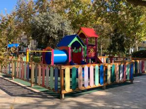 a colorful playground in a park with a wooden fence at Alcalá Zona Centro in Alcalá la Real