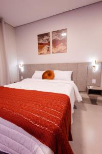 a bed with a orange cat laying on top of it at Hotel Golden Palace in Fonte Termal Água Quente