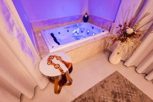 a bathroom with a tub with a table in it at Hotel Golden Palace in Fonte Termal Água Quente +26 photos