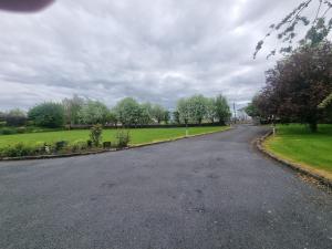 an empty road with trees on the side of the road at Oyster Lodge shared accomadation in Galway