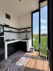 a kitchen with a sink and a large window at Parafrutts Apartments by Ateliero in Ubud