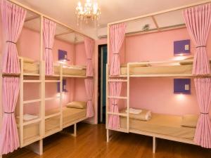 a room with bunk beds with pink curtains at Youki Haus Hostel in Montevideo +38 photos