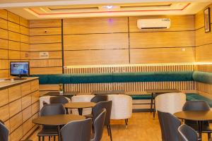 a dining room with tables and chairs and a tv at Indian Atlantic Hotel & Suites in Agbor
