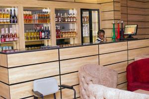 a man sitting at a bar in a restaurant at Indian Atlantic Hotel & Suites in Agbor
