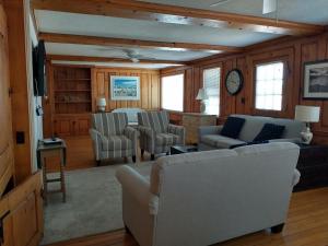 a living room with a couch and chairs and a clock at Wychmere Beach Club in Harwich Port