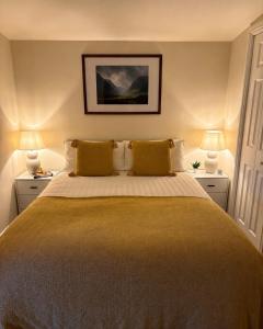 a bedroom with a large bed with yellow pillows at Minch View Cabin 1 in Earlish