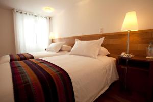 Postel nebo postele na pokoji v ubytování Hotel Plaza de Armas Cusco