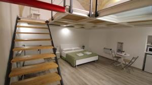 a bedroom with a bed and a ladder and a bunk bed at Mastropaolo42 Luxury B&B in Grottaglie
