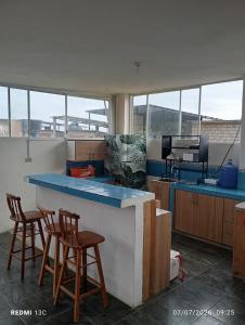 a kitchen with two stools and a counter top at Yemayá hostal in Puerto López