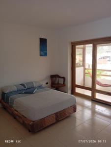a bedroom with a bed and a sliding glass door at Yemayá hostal in Puerto López