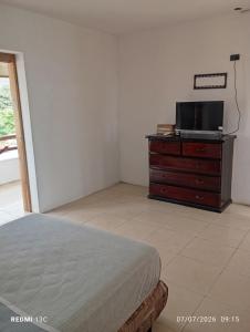 a bedroom with a bed and a tv on a dresser at Yemayá hostal in Puerto López