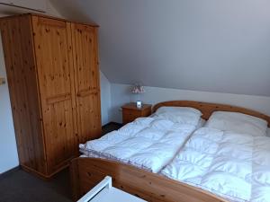 a bedroom with a wooden bed and a cabinet at Haus am Prerow-Strand in Prerow