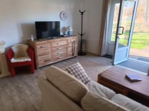 a living room with a couch and a tv at Haus am Prerow-Strand in Prerow