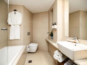 a bathroom with a sink and a toilet and a bath tub at Porto Veneziano Hotel in Chania +62 photos