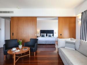 a living room with a couch and a bed at Porto Veneziano Hotel in Chania