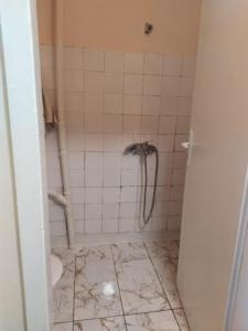 a bathroom with a shower in a tiled floor at Студио Търговище in Targovishte