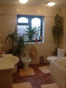 a bathroom with two sinks and a toilet and a window at The Cedars House B&B in Nuneaton