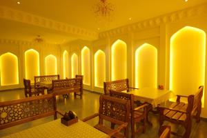 a restaurant with tables and chairs and yellow walls at Mashkobi Buxoro in Bukhara