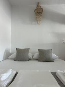 a bed with white sheets and pillows on it at Antiperatos Beach house in Karpathos