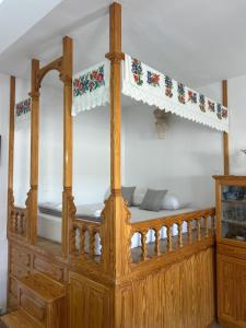 a wooden bed with a curtain on top of it at Antiperatos Beach house in Karpathos +20 photos