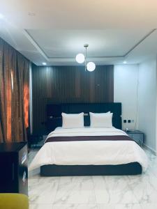 a bedroom with a large bed with white pillows at Soilsmart Haven in Abuja +12 photos