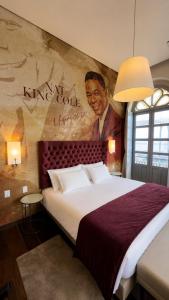 a bedroom with a large bed with a painting on the wall at Vila Galé Collection Opera - Sao Luis in São Luís
