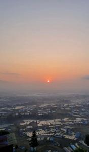 a sunset over a city with the sun in the sky at Cherry villa in Manamaiju