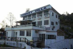 a white building with a sign on top of it at Cherry villa in Manamaiju