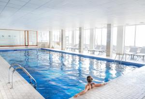 a woman is sitting in a swimming pool at L’Horizon Beach Hotel & Spa in St. Brelade