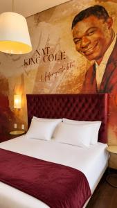 a bedroom with a large bed with a painting on the wall at Vila Galé Collection Opera - Sao Luis in São Luís