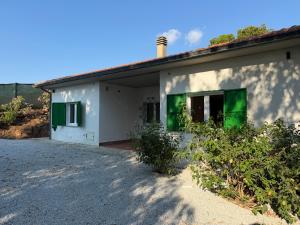 a white house with green shutters on it at Marinella Retreat - Brezza in Zambrone