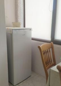a small refrigerator and a chair in a room at Студио Търговище in Targovishte