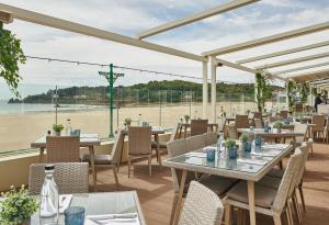 a restaurant with tables and chairs and a view of the ocean at L’Horizon Beach Hotel & Spa in St. Brelade